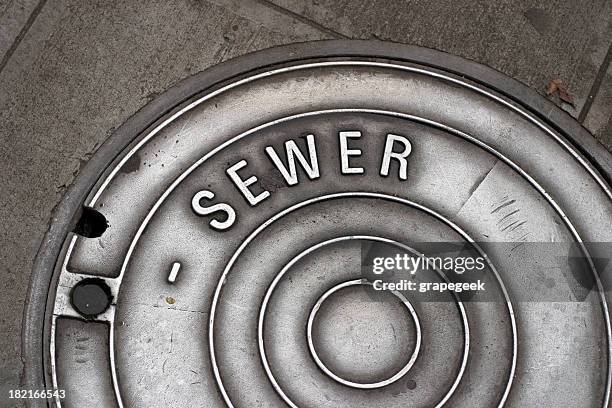 sewer manhole cover - riool stockfoto's en -beelden
