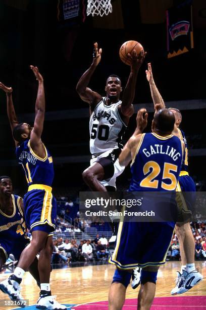David Robinson of the San Antonio Spurs drives to the basket for a layup against the Golden State Warriors at the Alamodome during the 1996 season in...