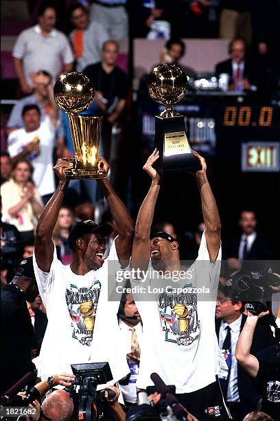 David Robinson holds up the NBA Championship trophy as Tim Duncan of the San Antonio Spurs holds up the MVP after winning Game Five of the 1999 NBA...