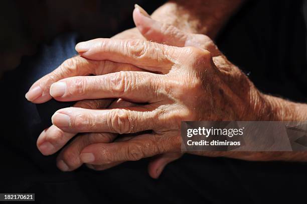 senior man's arthritic hands in shadow. - arthritic hands stock pictures, royalty-free photos & images