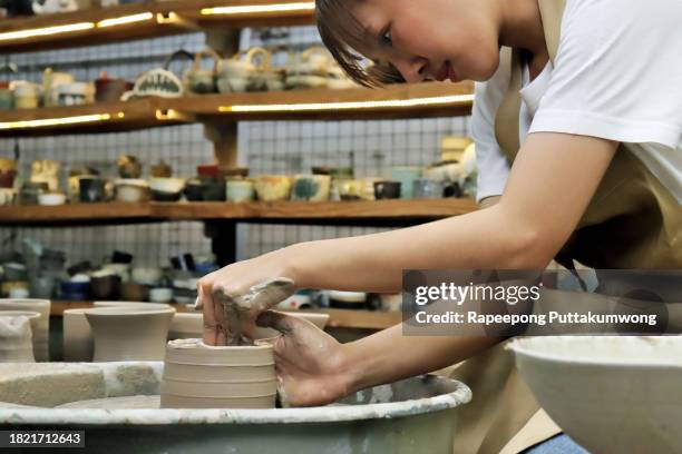 women working on the potter's wheel. hands sculpts a cup from clay pot. workshop on modeling on the potter's wheel - east asian works of art specialist stock pictures, royalty-free photos & images