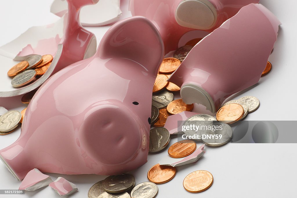 Coins strewn around broken pink piggy bank