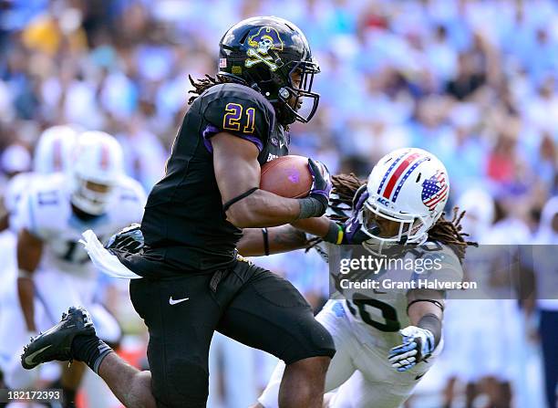 Vintavious Cooper of the East Carolina Pirates runs against Tre Boston of the North Carolina Tar Heels during play at Kenan Stadium on September 28,...