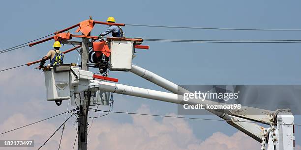 two workers in a crane repairing a power pole - power line stock pictures, royalty-free photos & images