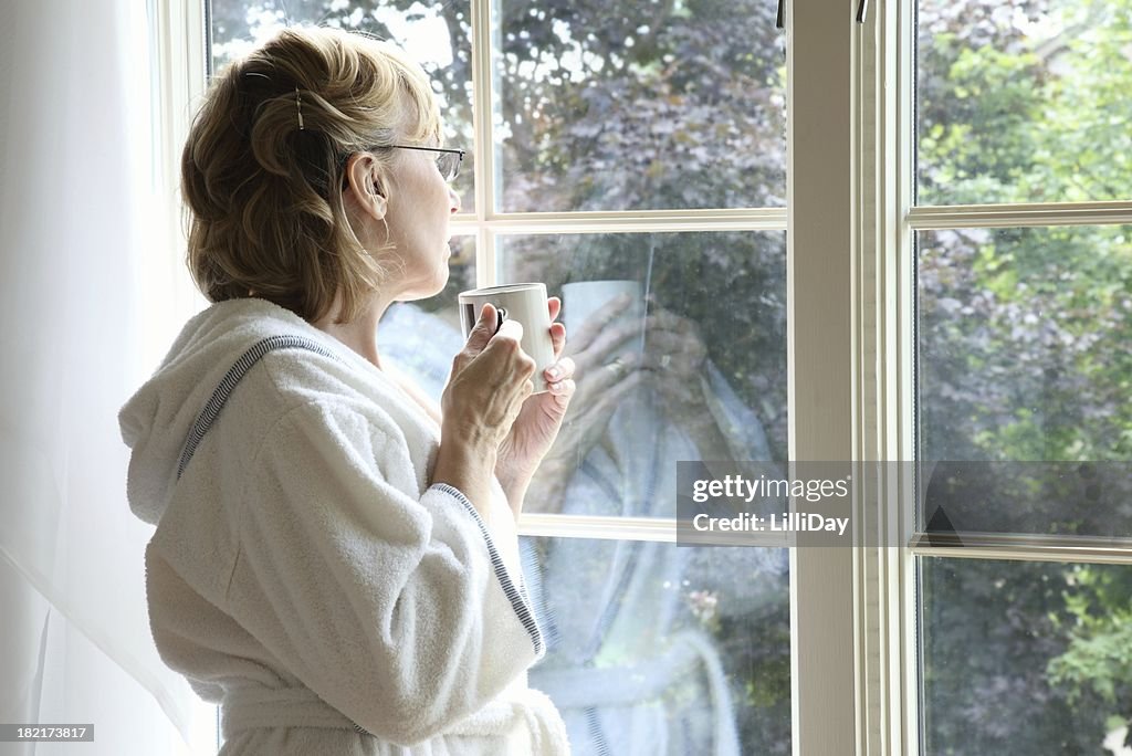 Woman Drinking Coffee Looking Out Window