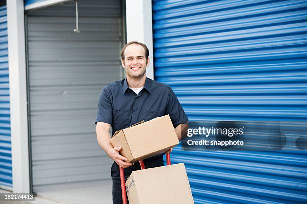 hombre con cajas móviles en el almacenamiento de la empresa - self storage fotografías e imágenes de stock