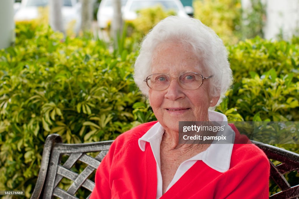 Happy Senior Woman sitting outdoors in the garden