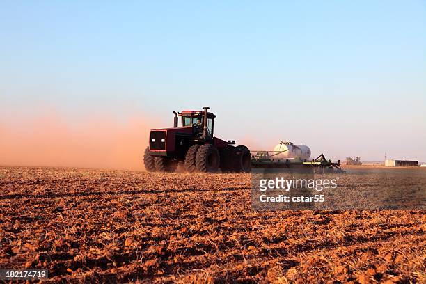 agriculture: farmer driving tractor with fertilizer tank in plowed field - oklahoma stock pictures, royalty-free photos & images