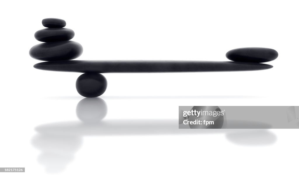 Balancing smooth black stone with reflection