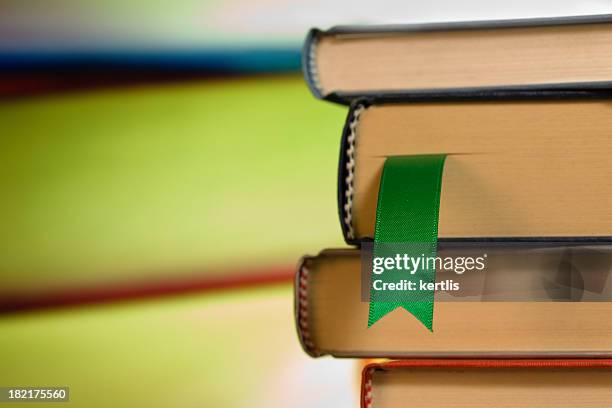 close-up of green ribbon bookmark in a stack of books - bookmark stock pictures, royalty-free photos & images