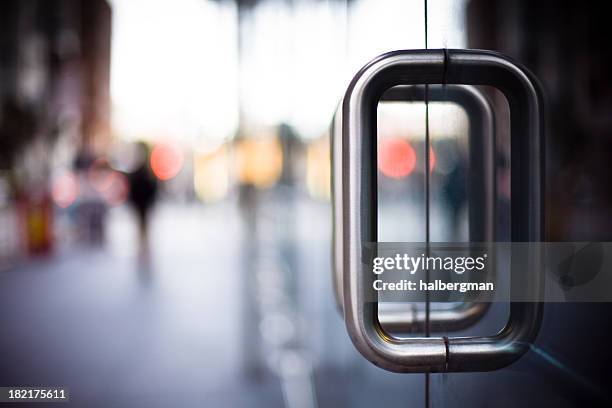 door handles on a glass office building - ingang stockfoto's en -beelden