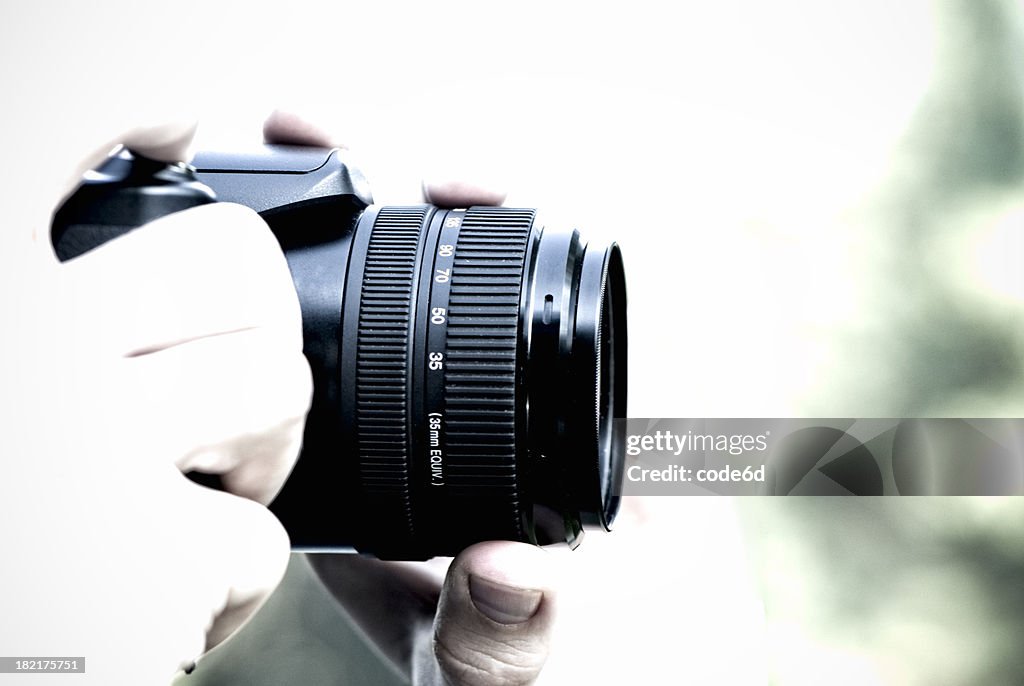 Photographer holding professional camera, high key, copy space