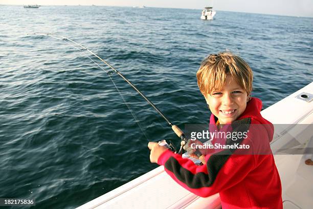 fishing vacation cute boy on boat - gulf coast states stock pictures, royalty-free photos & images