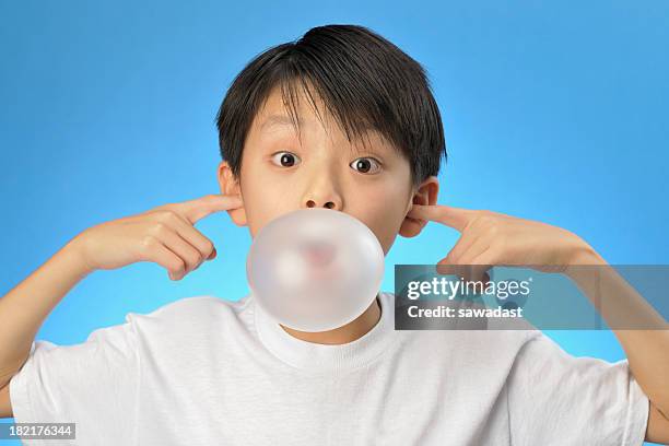 asian boy plugging his ears and blowing a bubble - bubble gum kid stock pictures, royalty-free photos & images