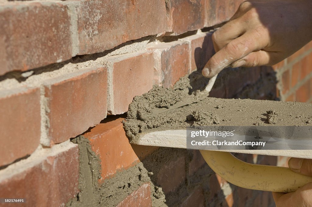 Construction Travailleur Repointing de briques avec de nouveaux ciment