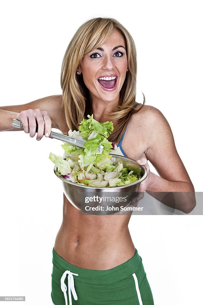 Cute woman tossing a salad