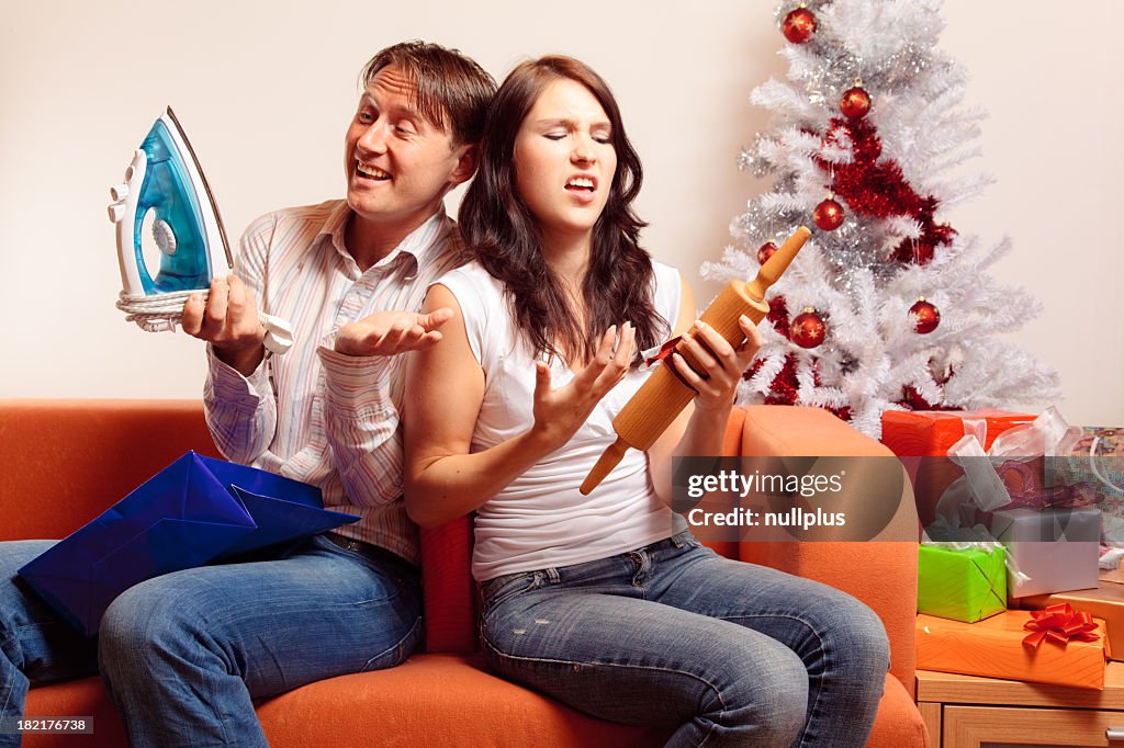 Young couple exchanging christmas gifts (series)