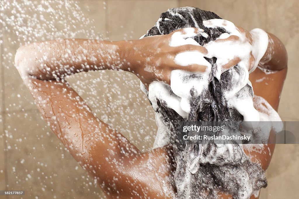 Woman washing her hair with shampoo