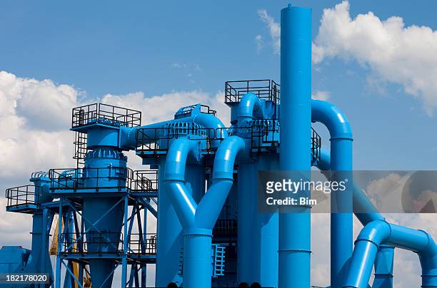 blue factory against cloudy sky - steel tubing stock pictures, royalty-free photos & images