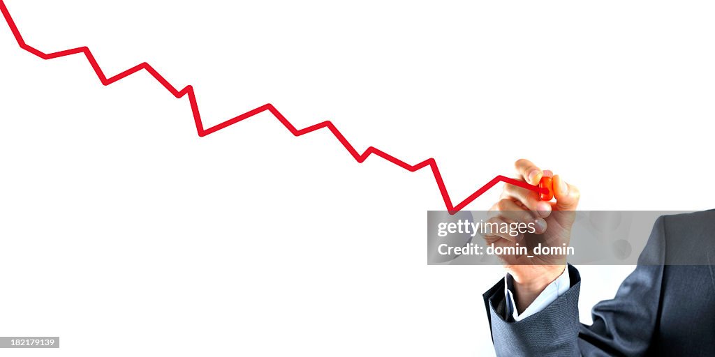 Businessman is drawing a graph with red line going down