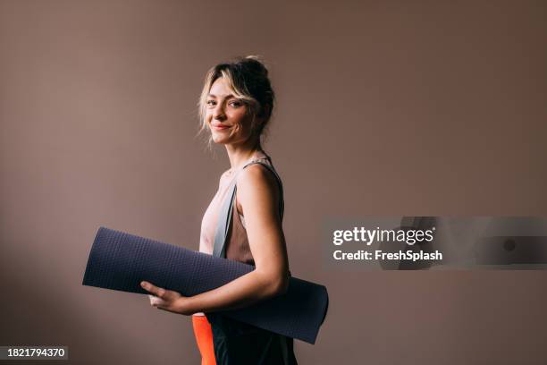 yoga-enthusiast: blonde frau bereit für trainingseinheit - sporttasche stock-fotos und bilder