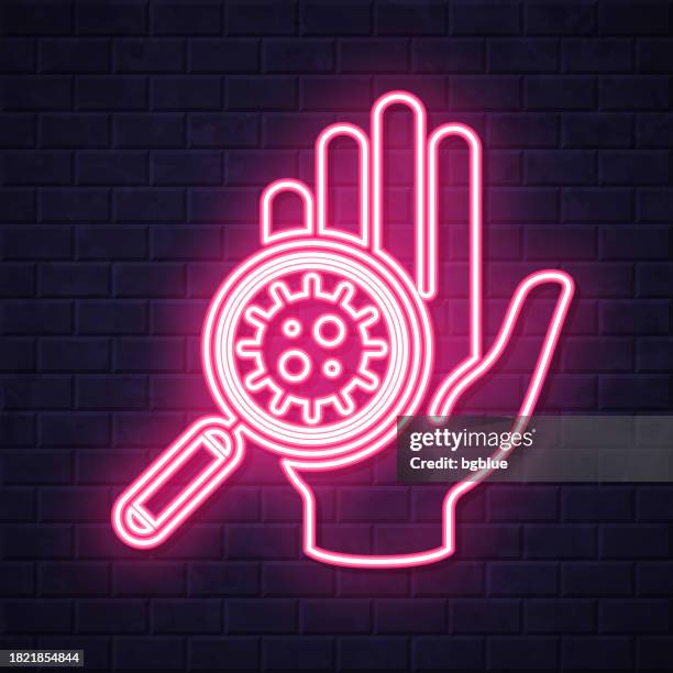 hand contaminated with coronavirus. glowing neon icon on brick wall background - looking over wall stock illustrations