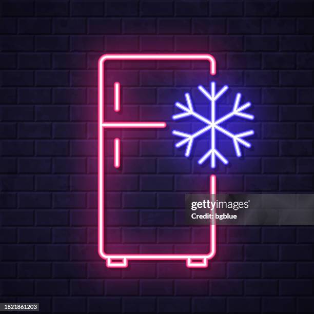 kühlschrank mit schneeflocke. leuchtende neon-ikone auf backsteinwandhintergrund - freezer icon stock-grafiken, -clipart, -cartoons und -symbole