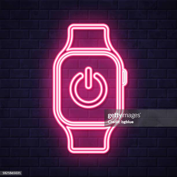 smartwatch with power button. glowing neon icon on brick wall background - clock on wall stock illustrations
