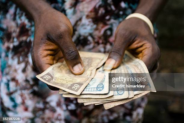 hands holding liberian money - liberia stock pictures, royalty-free photos & images