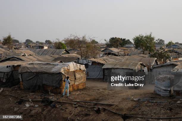 Man brushes his teeth near a drainage ditch at Internally Displaced Persons camp on November 30, 2023 in Bentiu, South Sudan. Climate change has...