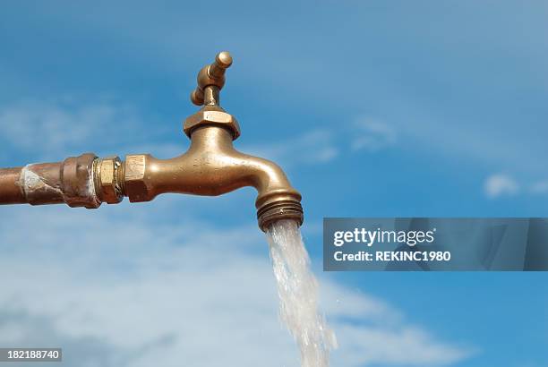 open water faucet against a blue sky - water tower storage tank stock pictures, royalty-free photos & images