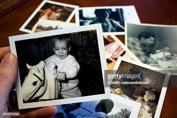 hand holds vintage photograph of child with hobby horse toy - child photos stock pictures, royalty-free photos & images