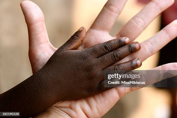 african and american hands - orphan boy stock pictures, royalty-free photos & images