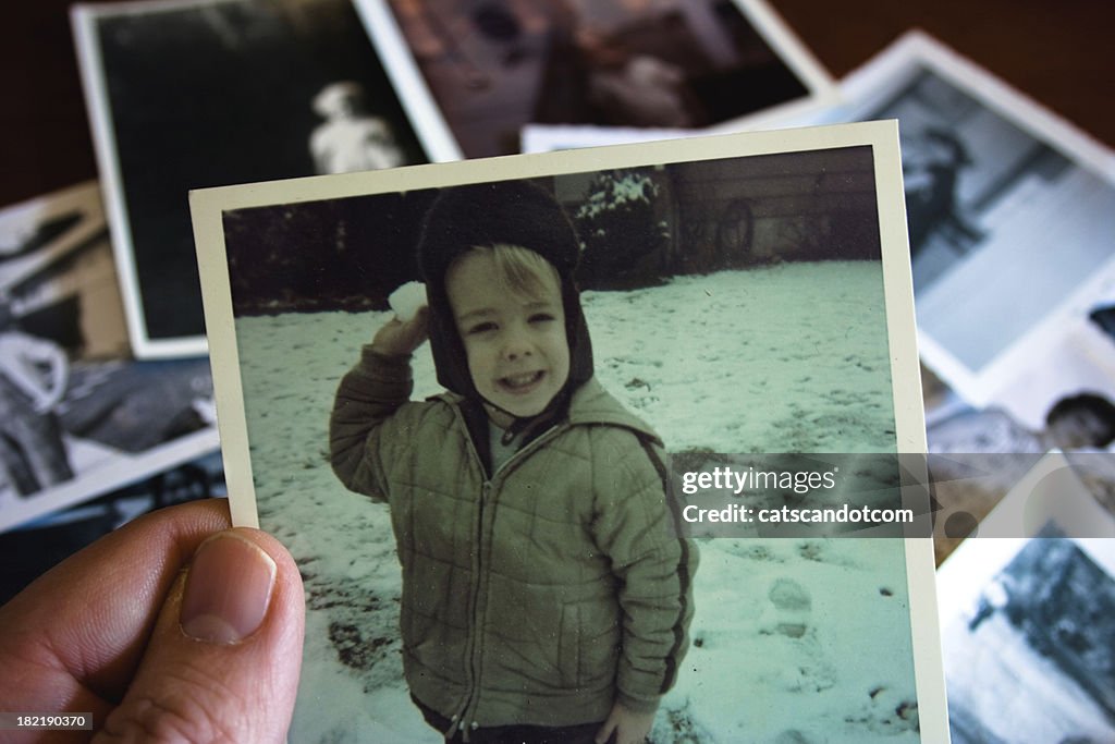 Mano tiene fotografia Vintage con ragazzo nella neve