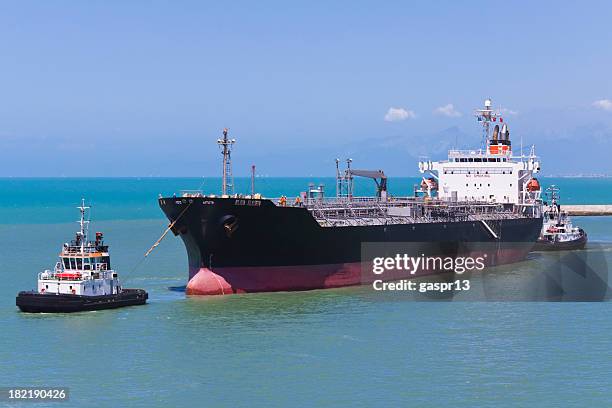 a ship being pulled by a tugboat in the water - oil tanker ship stock pictures, royalty-free photos & images