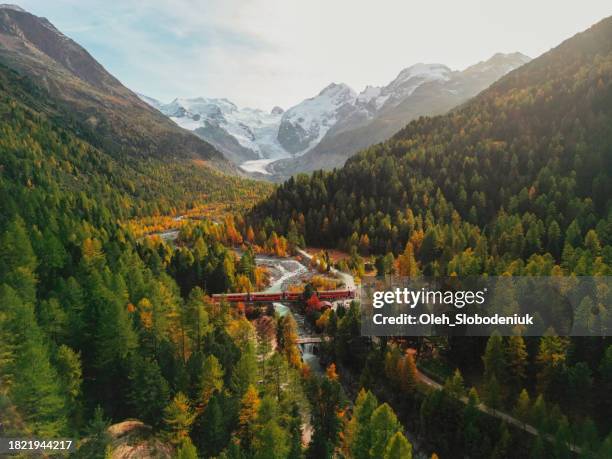 aerial view of train passing pristine landscape of piz bernina in swiss alps - engadin valley stockfoto's en -beelden