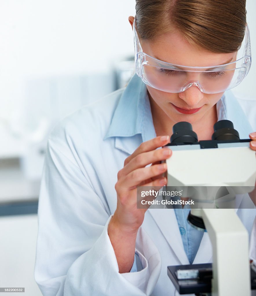 Female scientist working with a microscope