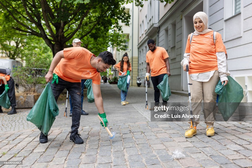 Team Of Diverse Volunteers Picking Up Litter From City Street High Res team-of-diverse-volunteers-picking-up-litter-from-city-street-high-res