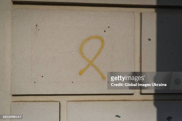 Graffiti sign of the Yellow Ribbon, resistance movement against the Russian occupation in the occupied territories of Ukraine, remains on a building...