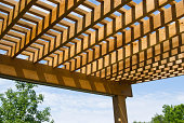 Cedar pergola with sky and trees in background