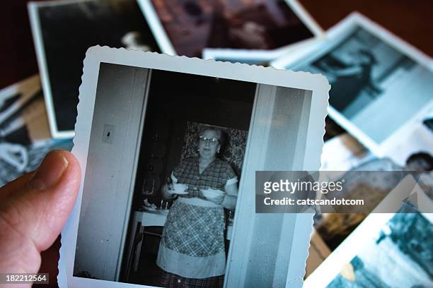 hand holds vintage photograph of 1950s grandma serving soup - 1960 kitchen stock pictures, royalty-free photos & images