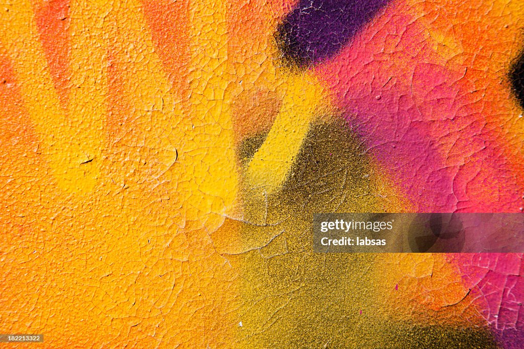 Colorful graffiti over a cracked surface