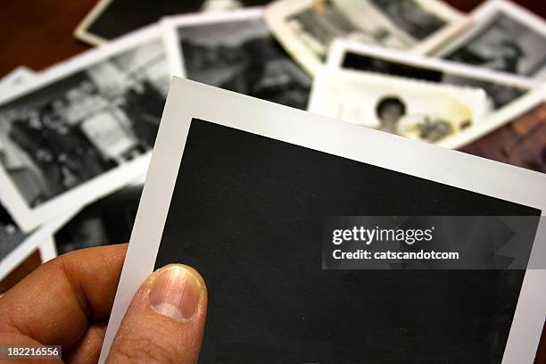 hand holds blank vintage photograph - looking at old photo stock pictures, royalty-free photos & images