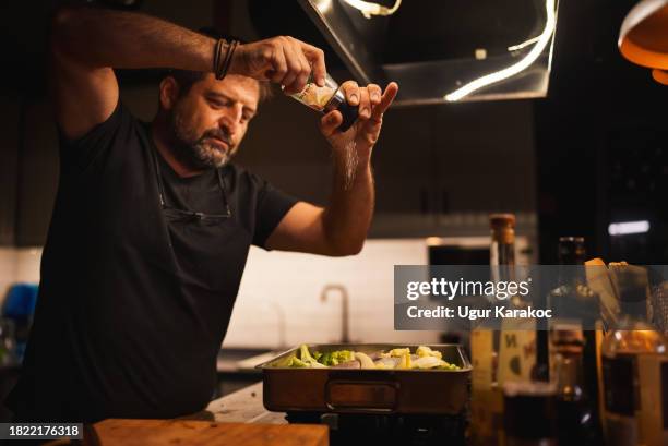 homem adicionando tempero do moedor de sal para a comida - sal de cozinha - fotografias e filmes do acervo