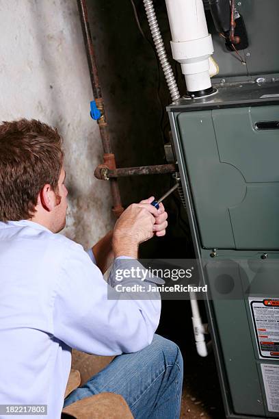 a service man working on a home furnace - furnace stock pictures, royalty-free photos & images