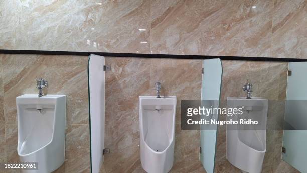 urinal in bathroom with marmer wall - marmer background stock-fotos und bilder