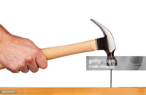 a hand holding a hammer ready to hammer a nail - hamer stockfoto's en -beelden
