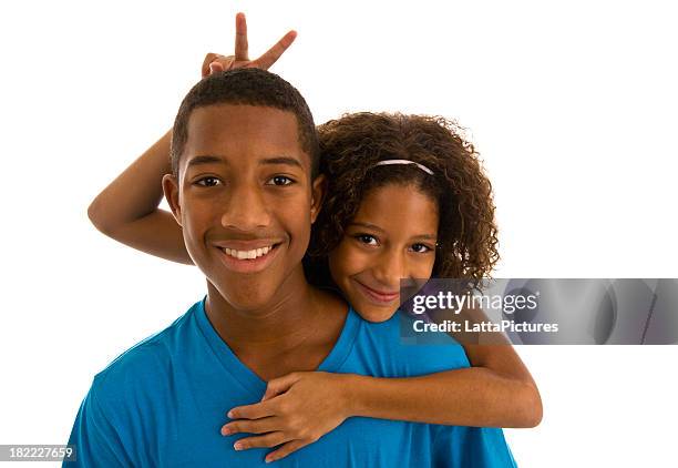 teenage boy and sister embracing and gesturing bunny ears - teen sibling stock pictures, royalty-free photos & images