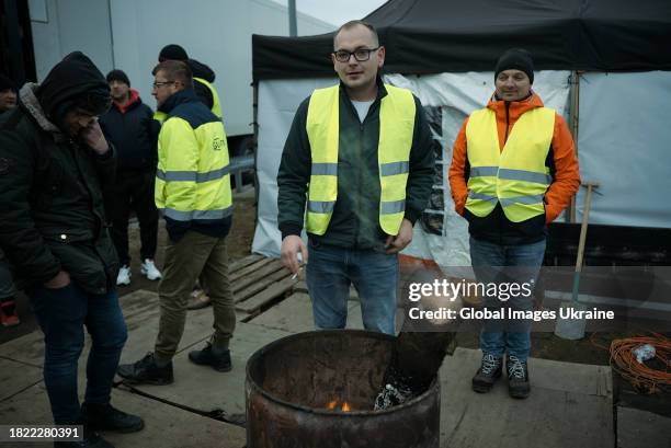 Polish protesters warm themselves by a fire pit during a strike near the Polish-Ukrainian border crossing Korczowa on November 27, 2023 in Korczowa,...