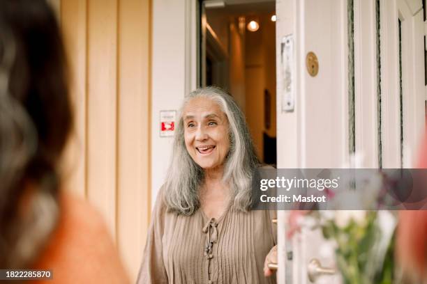 excited senior woman standing at doorway of house - open day 13 stock pictures, royalty-free photos & images